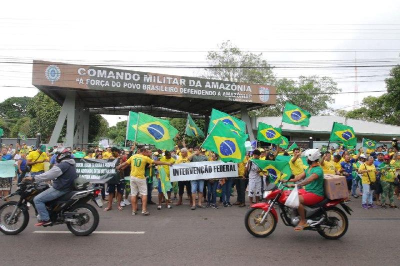 Manifestantes vestidos de verde e amarelo fazem manifestação em frente ao CMA